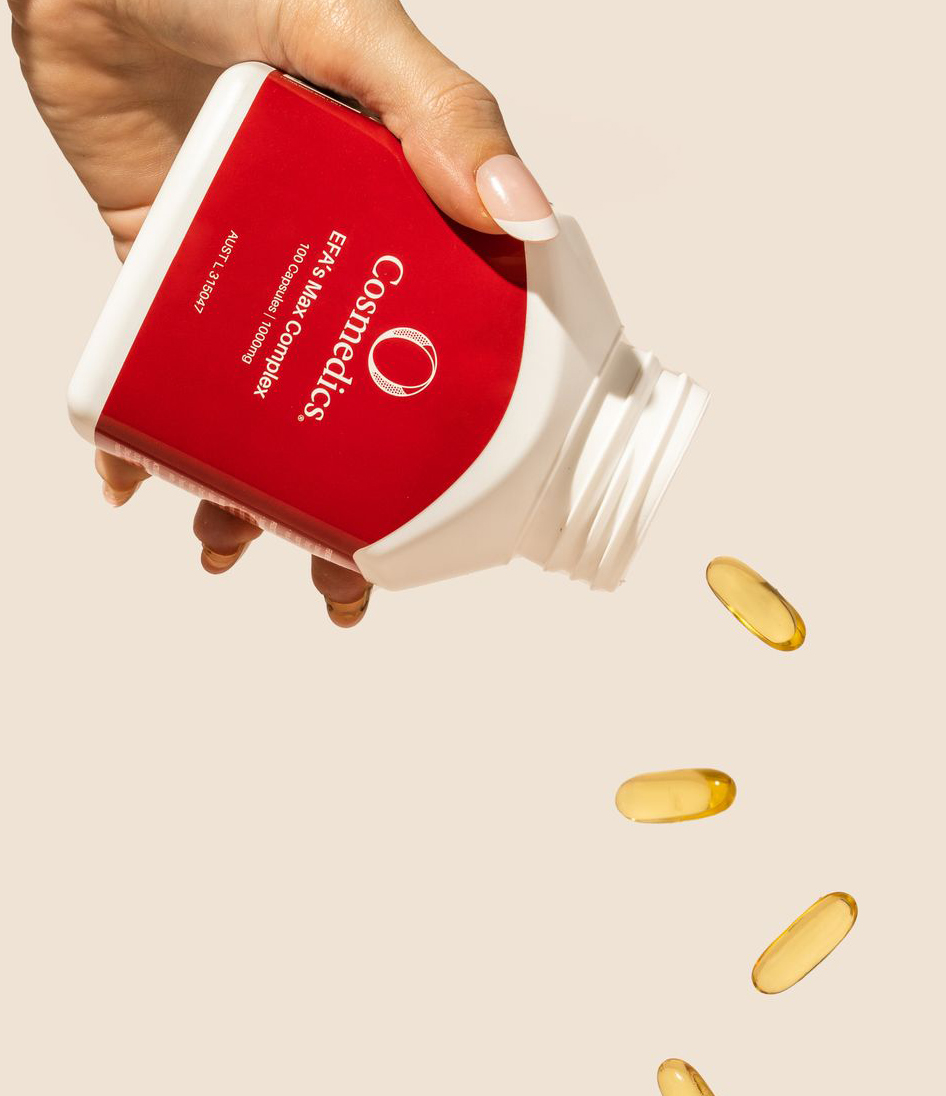 A hand pouring pills out of O Cosmedics EFAs Max Complex, which contains Omega 3, 6 & 9 to help repair skin barrier